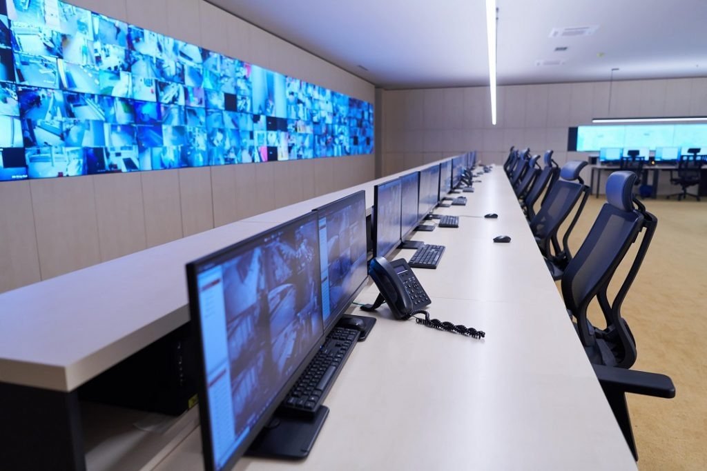 High-tech security control room with multiple monitors displaying live feeds for 24/7 surveillance operations. CCTV monitoring company in UK